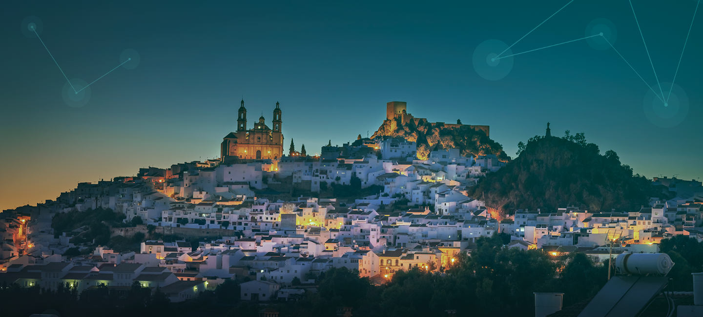 Un pueblo al atardecer con figuras digitales en el cielo