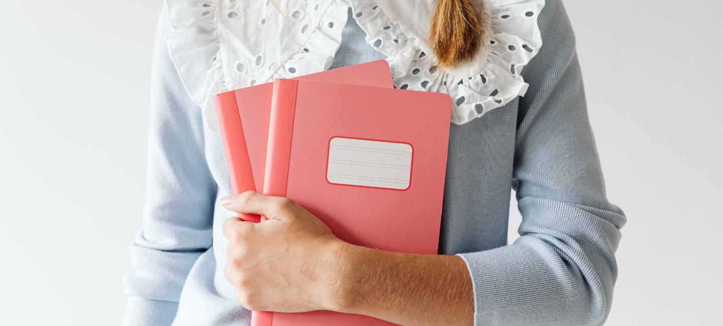 Mujer sosteniendo cuadernos en los brazos