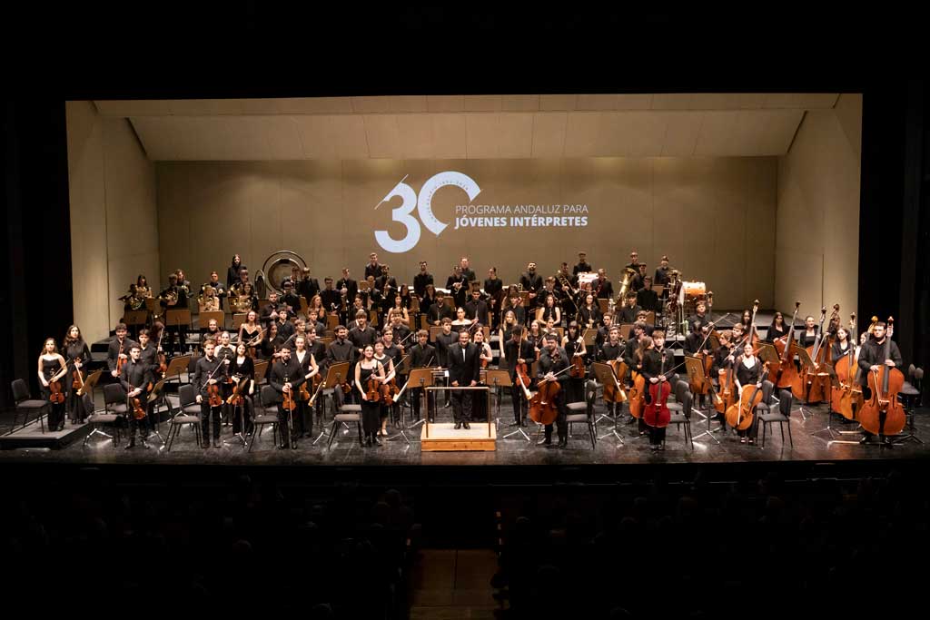 Integrantes de una orquesta sobre un escenario