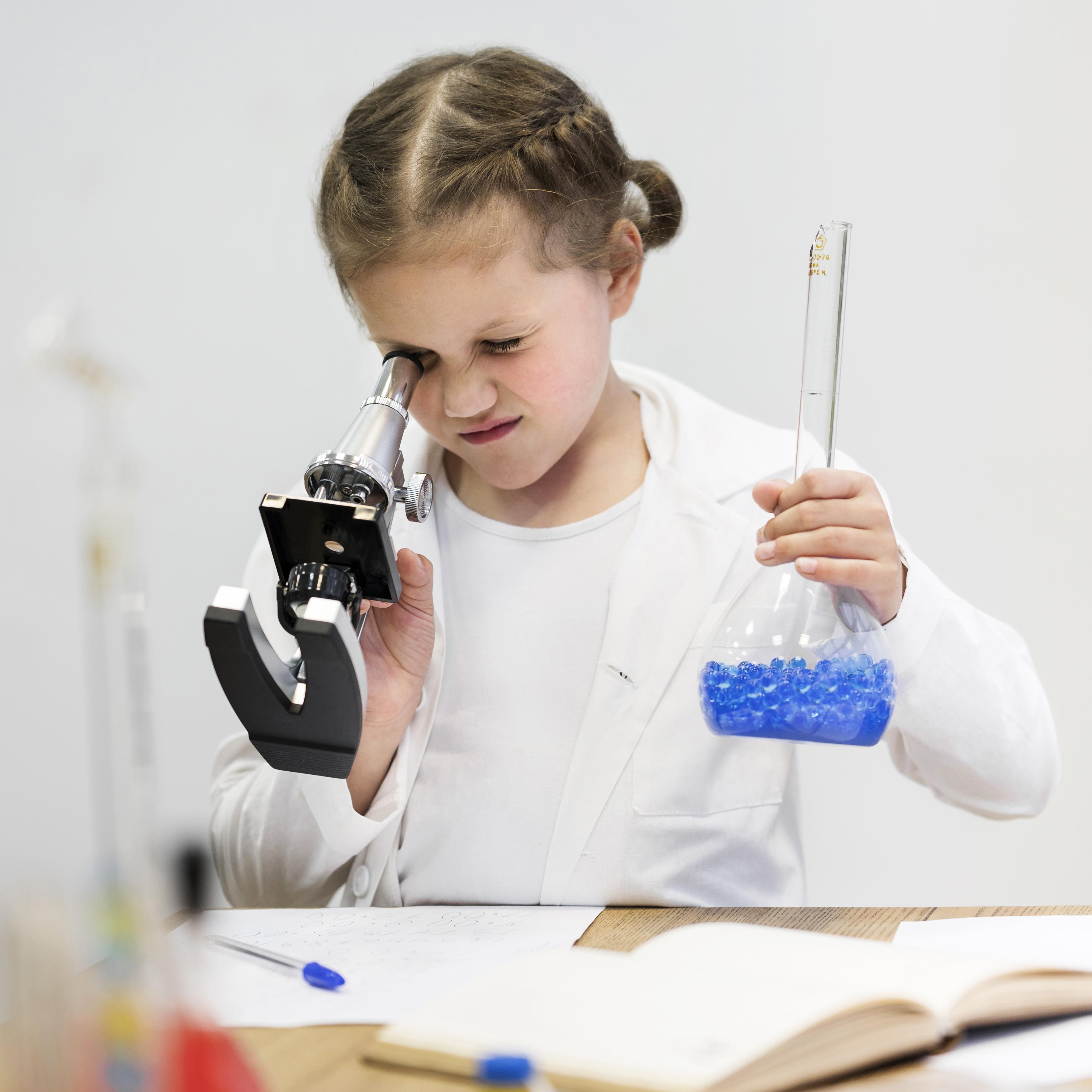 Niña con un microscopio